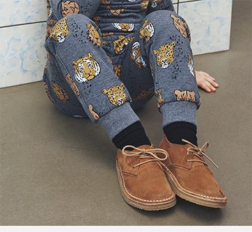 Person i dyremønstrede pyjamas og brune sko.