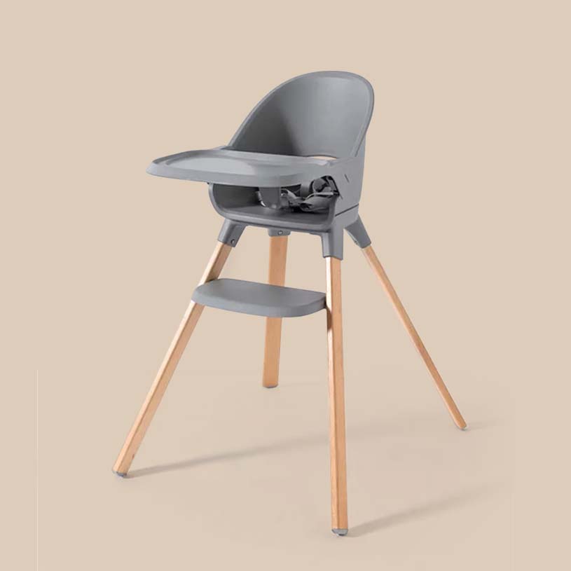 Grå høj stol med træben på beige baggrund.