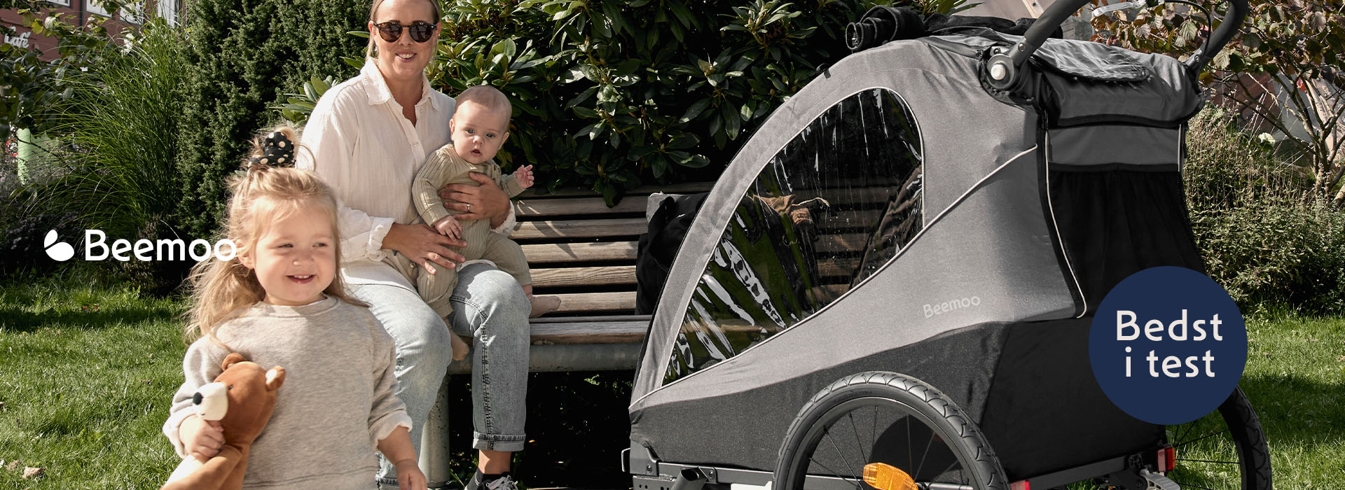 Familie på bænk med barnevogn i haven.