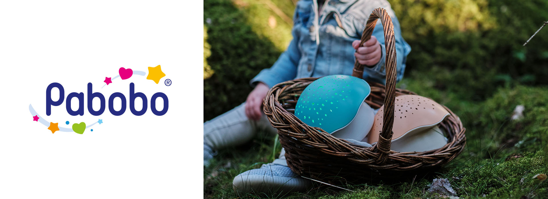 Barn holder en kurv med natlamper i skoven, Pabobo-logo til venstre.