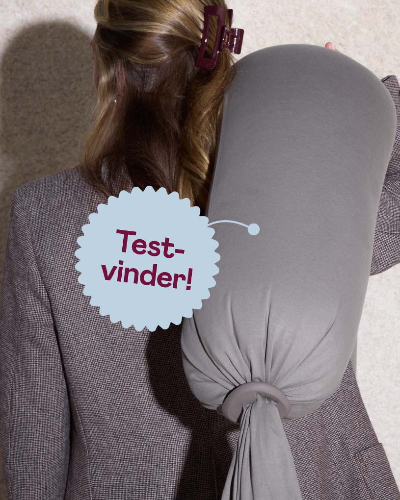 Kvinde bærer en grå gravid- og amningspude med teksten 'Bedst i test'.