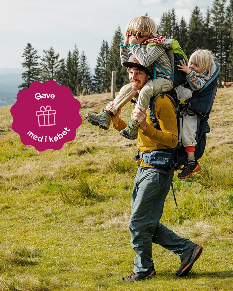 Far bærer barn i bærestol på fjeldtur. Mærke: Gave med i købet