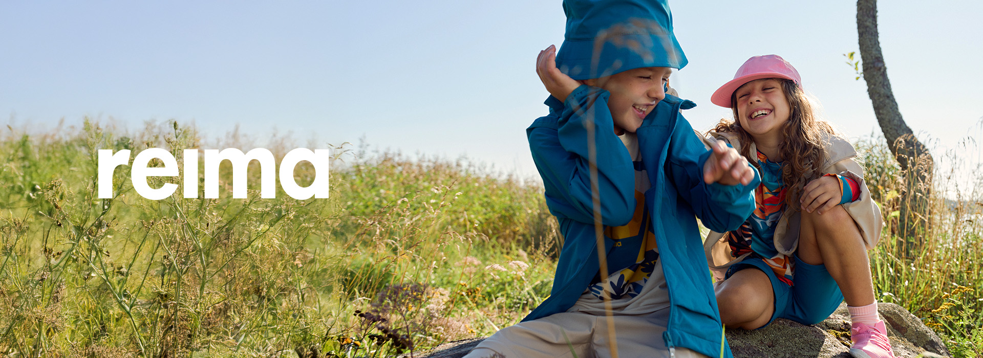 Børn leger i regnen med farvestrålende regntøj i en skov.