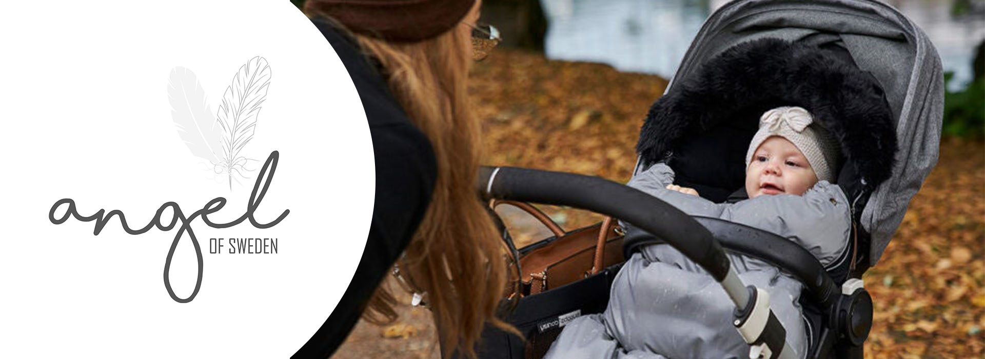 Baby i grå klapvogn med fjer og Angel of Sweden logo.