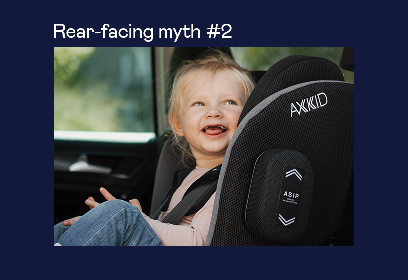 Barn griner i en bagudvendt autostol fra Axkid.