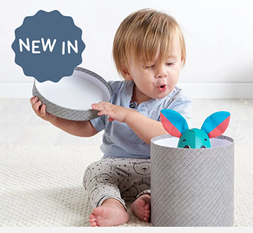 Lille barn åbner en boks med et legetøj indeni.