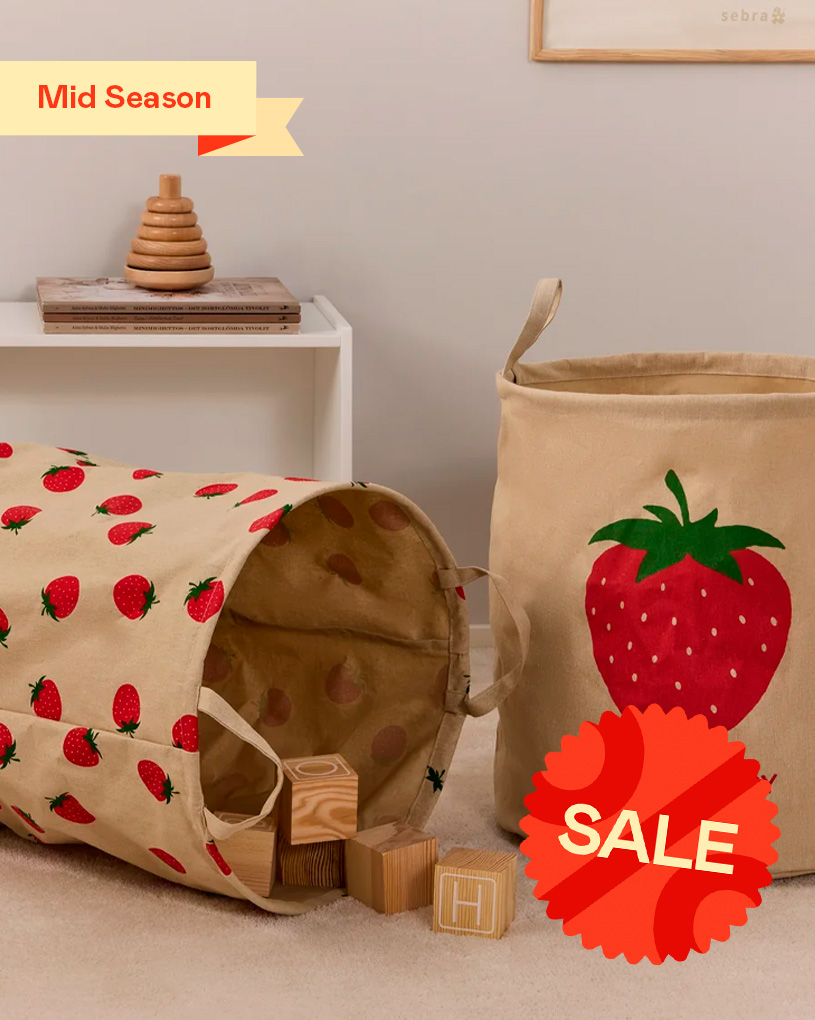Børneværelse med stofkurv og legetunnel med jordbær. Tekst: “Mid Season”.
