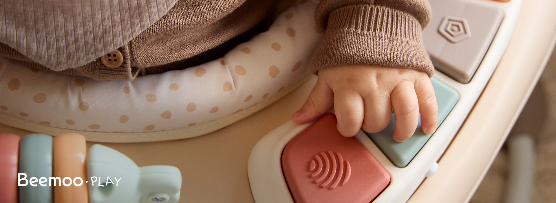 To børn leger med klodser ved et bord. Beemoo Play-logo til venstre.