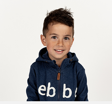 Smilende barn i blå hættetrøje mod hvid baggrund.