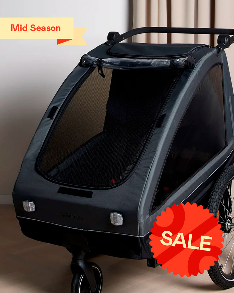 Sort barnevogn/transportvogn på hjul. Tekst: “Mid Season”.