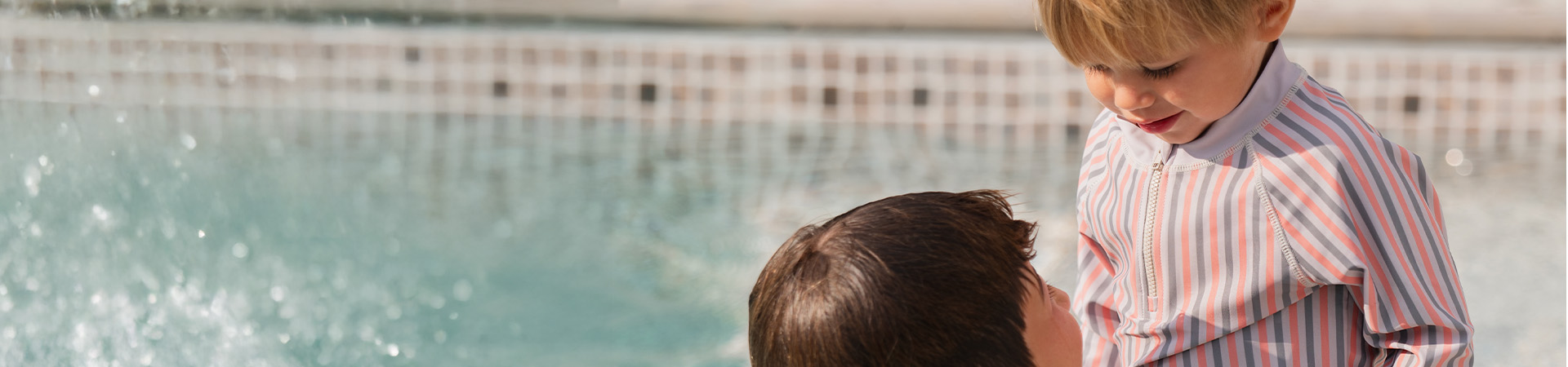 Mor smiler til sit barn, som holder en blomst, med teksten 'Kenza X Viking'.