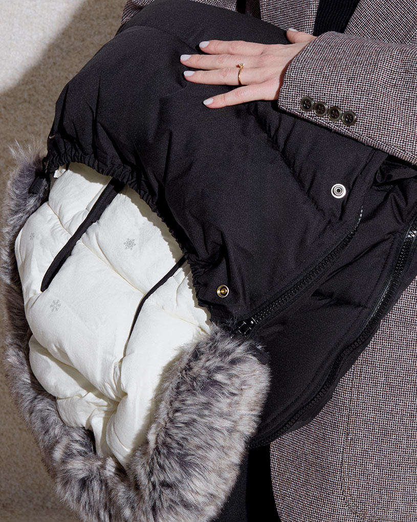 En sort åkpåse med en hvid inderside og pelskant, med teksten 'BabyWeeks'.