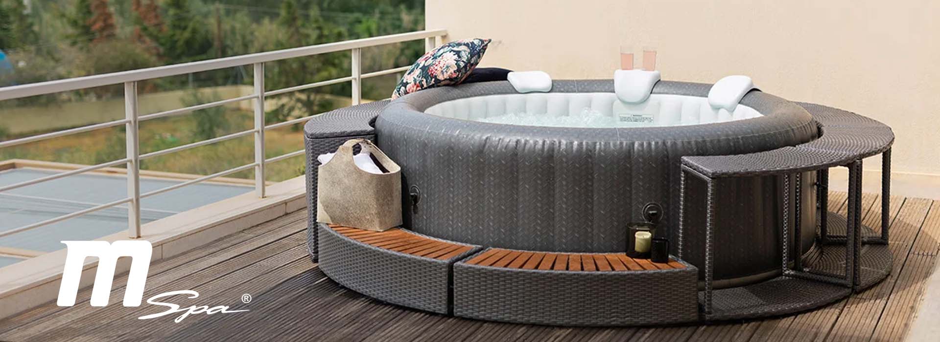 Oppustelig jacuzzi på terrasse med puder og drikkevarer.
