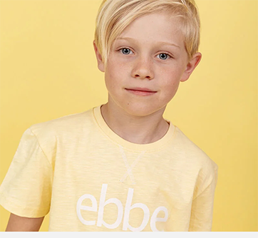 Barn i gul t-shirt mod gul baggrund.