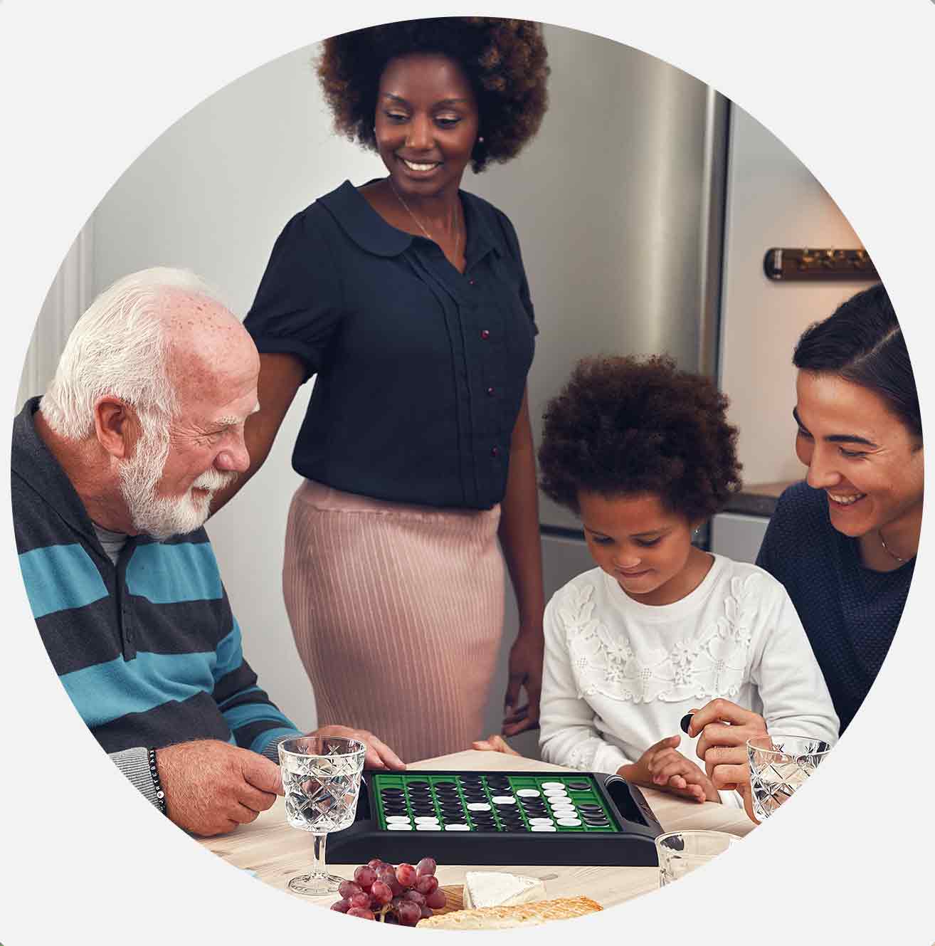 Fire personer spiller brætspil ved et bord med mad.