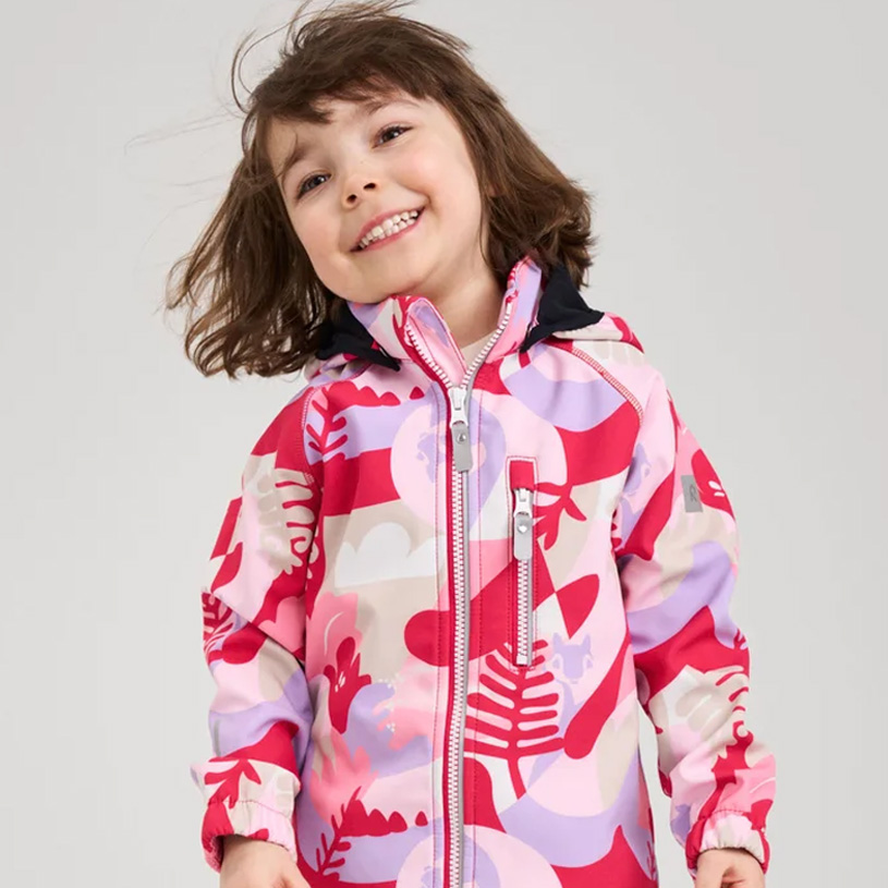 Tre børn i farverigt tøj står sammen.