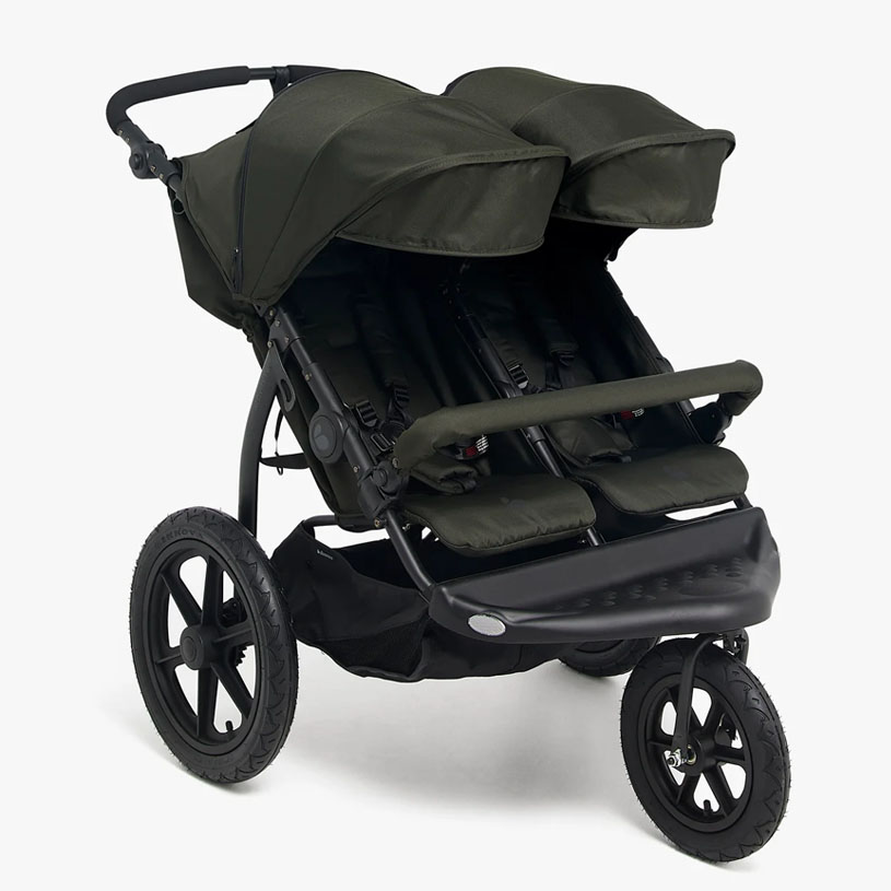 Dobbelt klapvogn med grå kalecher står indendørs.