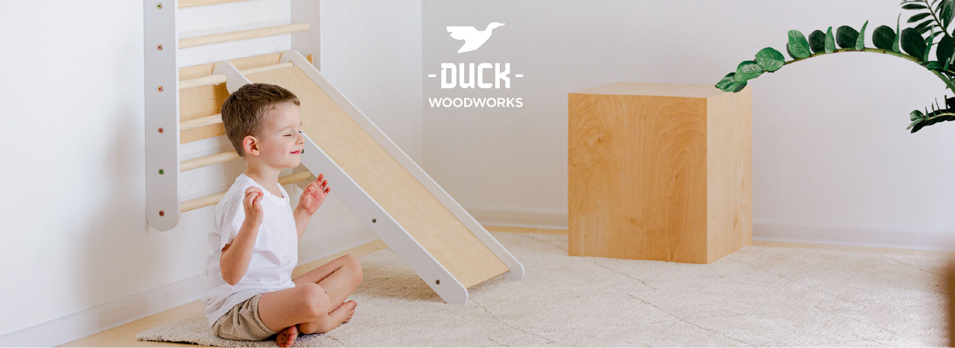 Barn mediterer foran træslegetøj i lyst værelse.