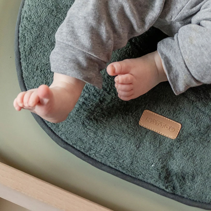 Åben pusleunderlag med bleer og lyserødt tæppe på en prikket tæppe.