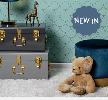 Bamse og stablede kufferter i et værelse med blå vægge.