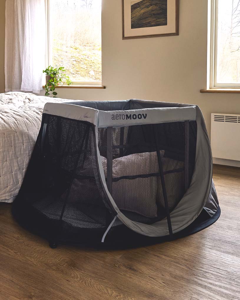 Rejseseng i soveværelse med trægulv og billede på væggen.