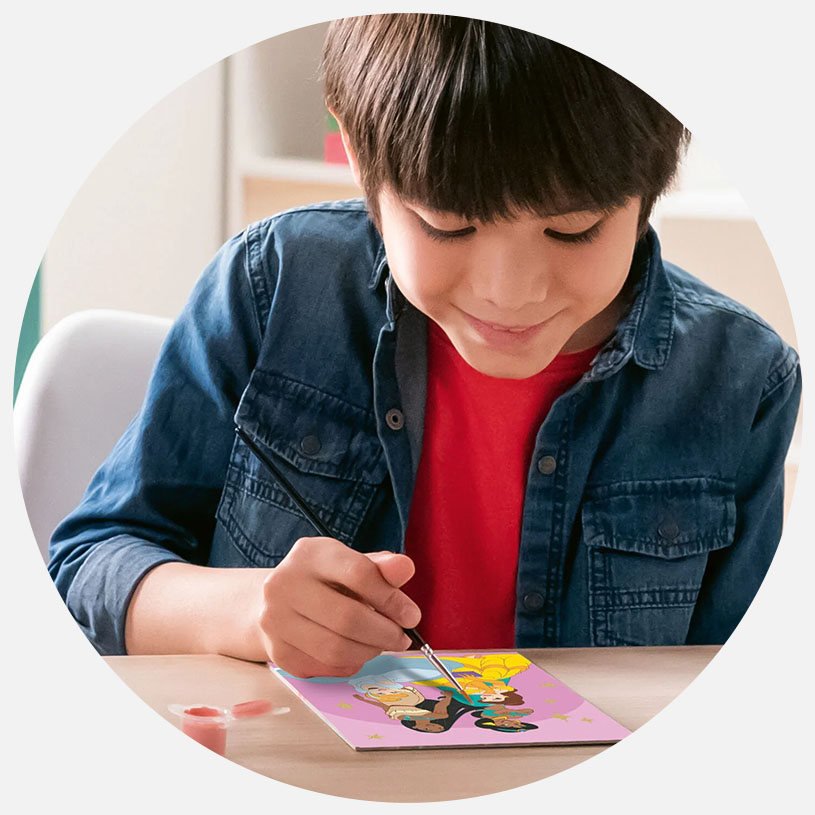 Barn maler et billede ved et bord.