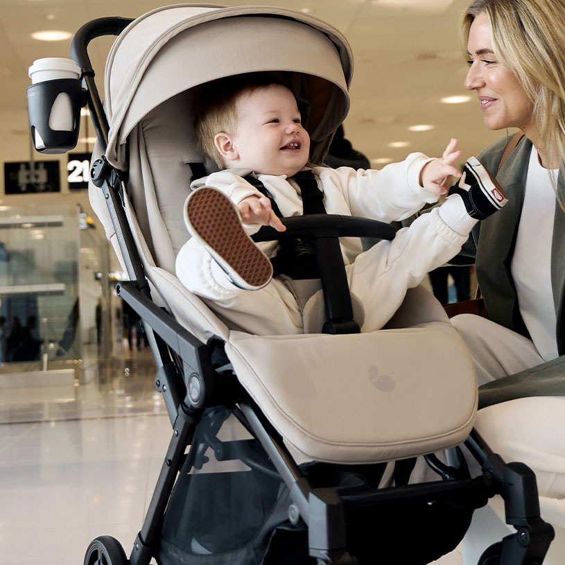 Kvinde går med barnevogn indenfor, teksten 'Nyhed!' ses.