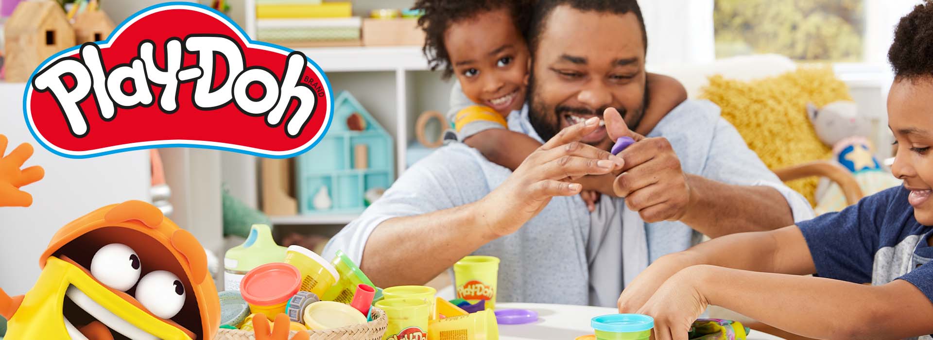 Far og barn leger med Play-Doh ved et bord.