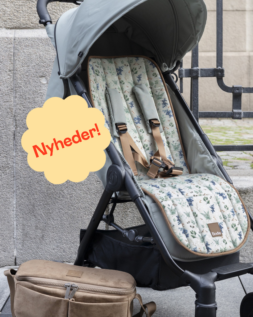 Barn sidder i en vogn og smiler, splash i billedet med teksten "Nyheder".