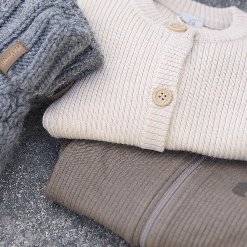 To børn i flyverdragter, den ene smiler og den anden holder et blad.