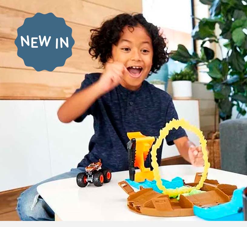 Barn leger begejstret med en legetøjsbil og bane på et bord.