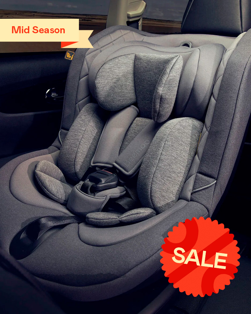 Grå autostol i bilen, polstret. Tekst: “Mid Season”.