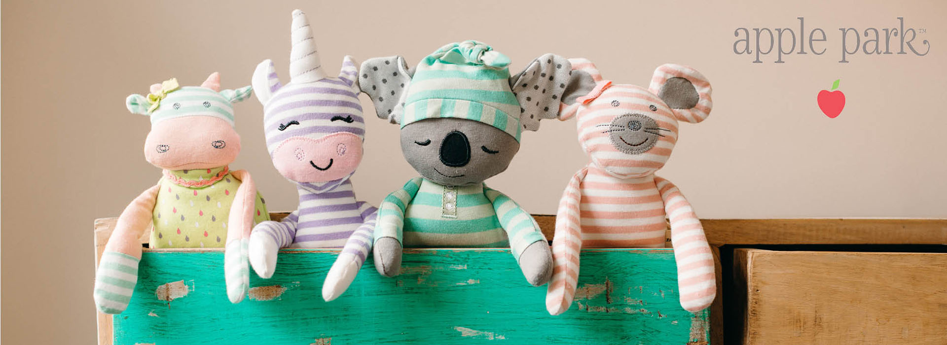 Fire bamser i pastelfarver på en trækasse.